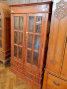 An Eastern hardwood glazed bookcase with pair panel doors enclosing shelves,