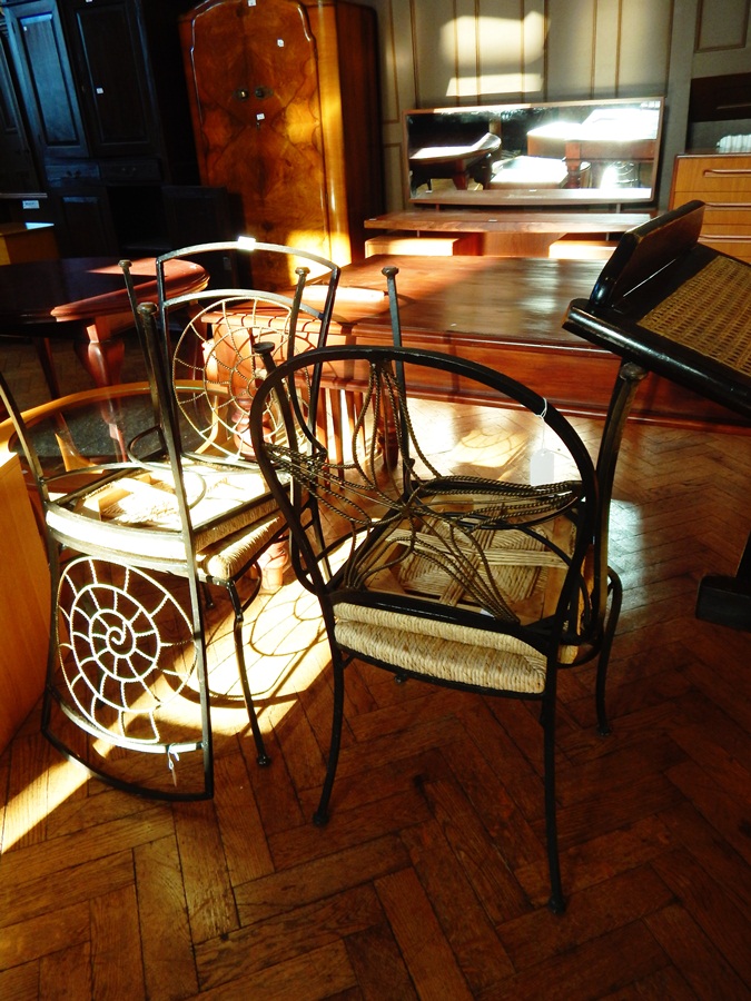 A set of four iron framed conservatory chairs, with rush seats,