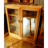 A modern elm display cupboard, the pair of double glazed panel doors enclosing shelves,