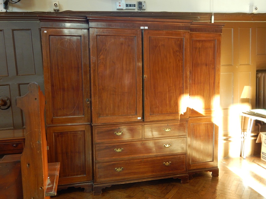 An Edwardian mahogany and line inlaid breakfront wardrobe/linen press having dentil moulded cornice,