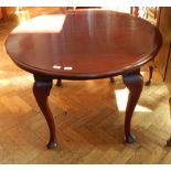 An early 20th century oval mahogany wind-out dining table on stout cabriole legs with pad feet