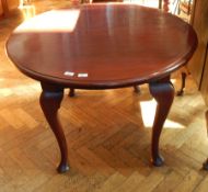 An early 20th century oval mahogany wind-out dining table on stout cabriole legs with pad feet