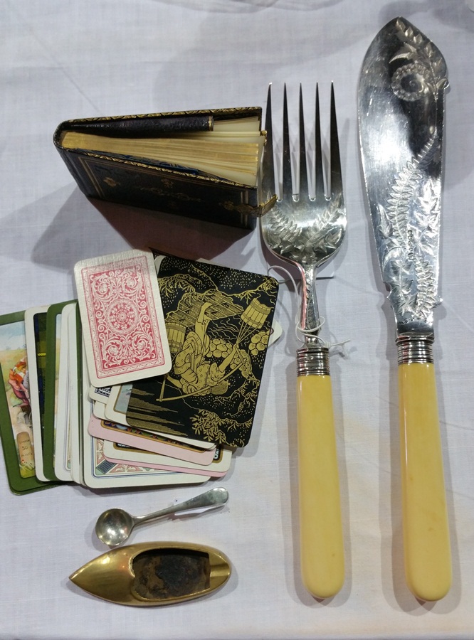 A pair of Victorian bone handled fish servers with a leather bound miniature notebook and playing
