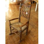 19th Century oak child's spindle back rocking armchair with rush seat and turned legs