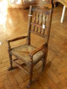 19th Century oak child's spindle back rocking armchair with rush seat and turned legs