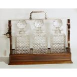 Edwardian inlaid mahogany and silver-plated three-bottle tantalus having hinged plated locking top