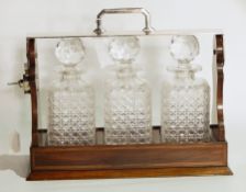 Edwardian inlaid mahogany and silver-plated three-bottle tantalus having hinged plated locking top