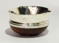 Early 20th century silver-mounted coconut cup with wavy and hammered rim and engraved borders,