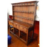 A late Georgian oak small dresser with raised three-tier plate rack, having ogee cornice,