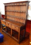 A late Georgian oak small dresser with raised three-tier plate rack, having ogee cornice,