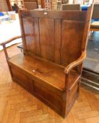 Antique oak settle with triple framed fielded panels to the back, open arms,