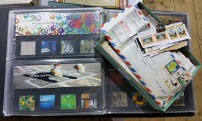 Three green folios of first day covers and a small box of loose stamps