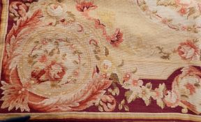 Woolwork rug with maroon bordering, floral decoration on a cream ground,