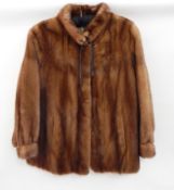 A 1960's/70's mink jacket with cuffed sleeves and a matching hat and leather tie details  Live