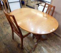 A teak extending dining table and set of four dining chairs by Nathan