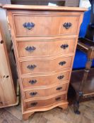 A stained pine chest of drawers with six drawers, swan neck handles, on block supports,