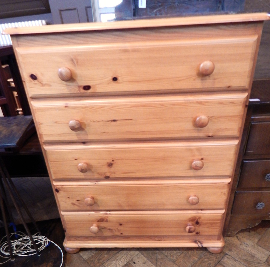 A pine chest of five long drawers, turned and bun feet,