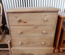 A modern pine chest of three long drawers raised on a plinth base,