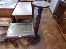 A nest of three mahogany occasional tables, with inset leather tops with glass covers,