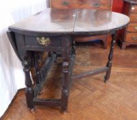 An 18th century oak oval top gateleg table, with a frieze drawer,