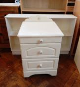 A contemporary white painted bedside table of three drawers,