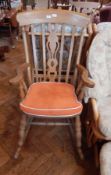 An modern oak rocking chair with open splats, serpentine handles,
