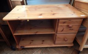 A modern pine bookcase, with rectangular top, two open shelves flanked by two drawers on bun feet,