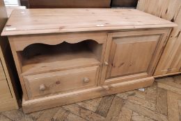 A pine television stand with cupboard and drawer,