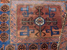 A small Eastern wool saddle rug on a blue and red ground with geometric pattern, gul border,