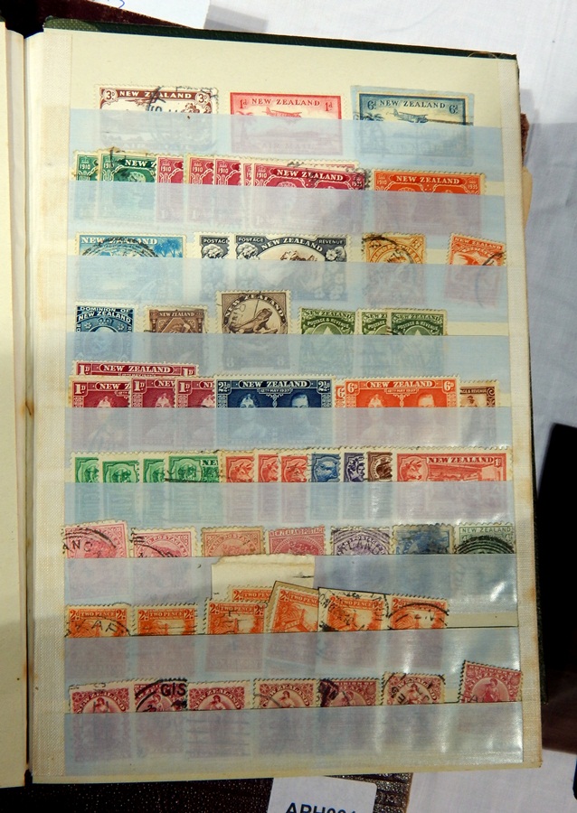 A green stockbook with stamps from around the world and the Imperial postage stamp album with