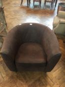 A modern leather tub armchair with loose cushion seat on turned tapering legs