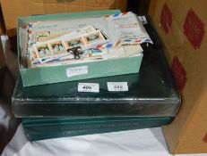 Three green folios of first day covers and a small box of loose stamps