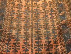 An Eastern wool rug with red field and geometric pattern,