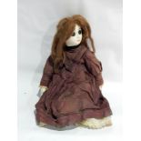 An antique painted papier mache and cloth doll with painted features, real hair,