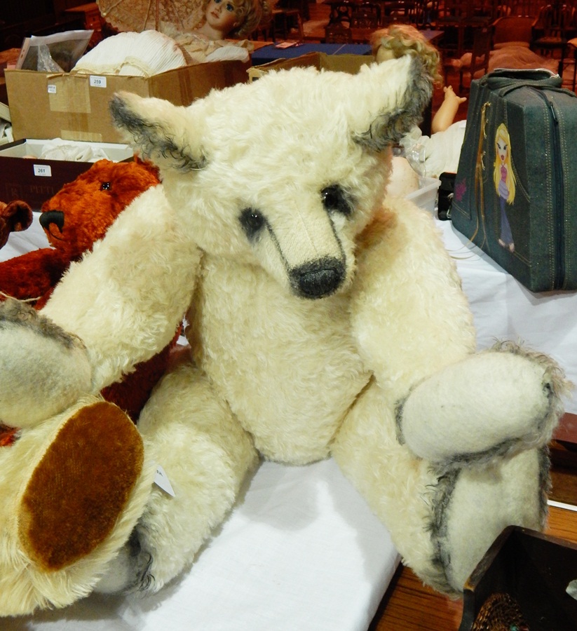 A white mohair bear with black painted ears and snout detailing, felt pads, jointed body,
