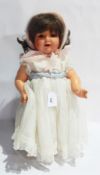 A mid 20th century French walking doll, circa 1936 to 1950, wearing cream dress and mohair bonnet,