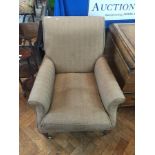 A Victorian armchair with herringbone upholstery raised on turned mahogany legs with brass castors,