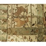 A wool carpet in green and beige depicting deer and other animals, on a cream ground,