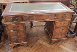 A modern mahogany veneer pedestal desk with inset writing surface, three frieze drawers,