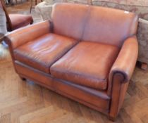 A Laura Ashley leather two seater sofa, with loose cushion seat, on square tapering legs,