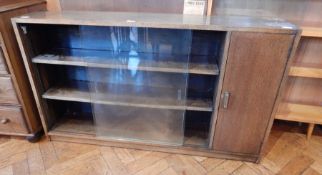 A modern oak bookcase with glazed sliding doors, and cupboard,