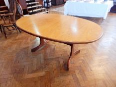 A modern oak extending dining table, on twin column supports, with curved splayed legs,