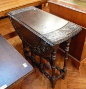 A late Victorian carved ebonised oak gateleg table, on turned legs united by stretchers,