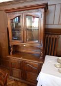 A modern continental style glazed dresser, with a pair of doors enclosing shelf, on turned supports,