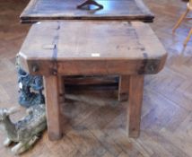 An old elm butchers block raised on square splayed legs,