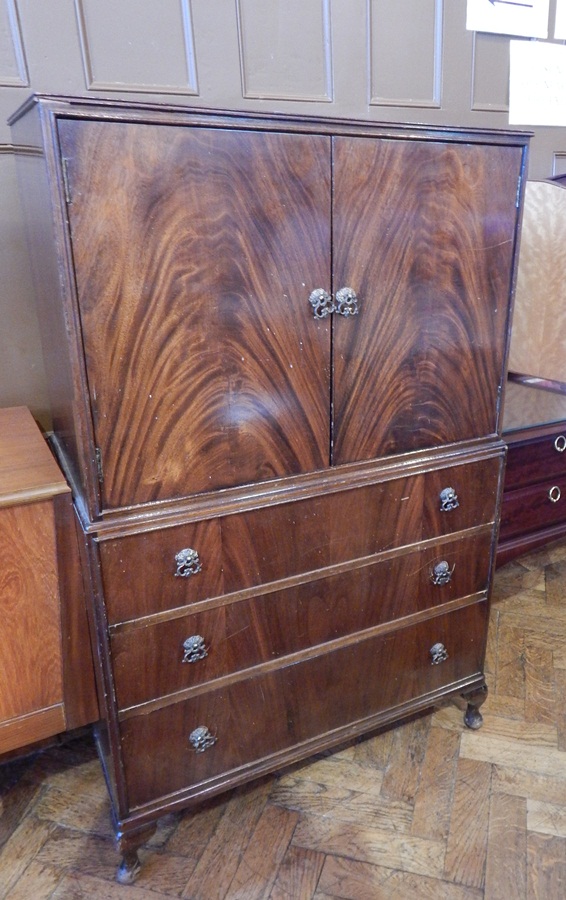 A reproduction mahogany veneered cabinet with pair panel doors enclosing shelf,