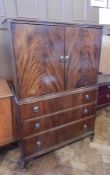 A reproduction mahogany veneered cabinet with pair panel doors enclosing shelf,