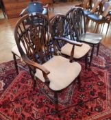 A set of six wheelback Windsor chairs with solid seats, on turned legs, one carver,