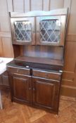 A stained oak glazed cupboard, the pair of leaded light panelled doors enclosing shelf,