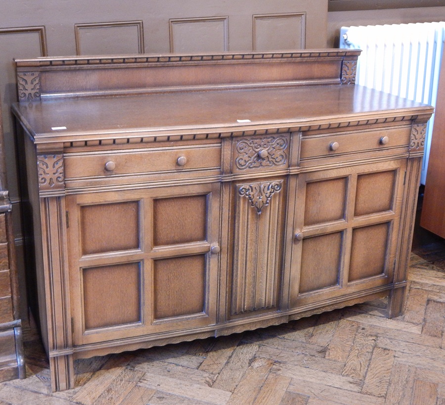 A reproduction oak breakfront sideboard with carved splashback,